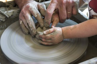 Potter çömlek çarkında seramik tabağı şekillendiriyor.
