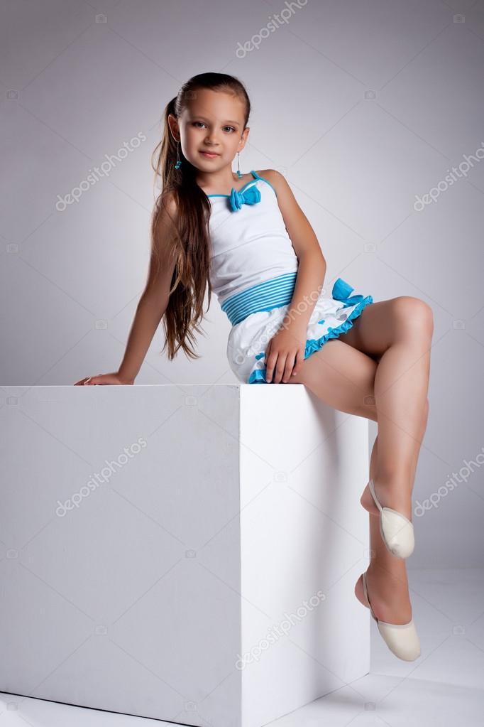 Young child in fashion cloth posing on cube Stock Photo by ©Wisky 12625282