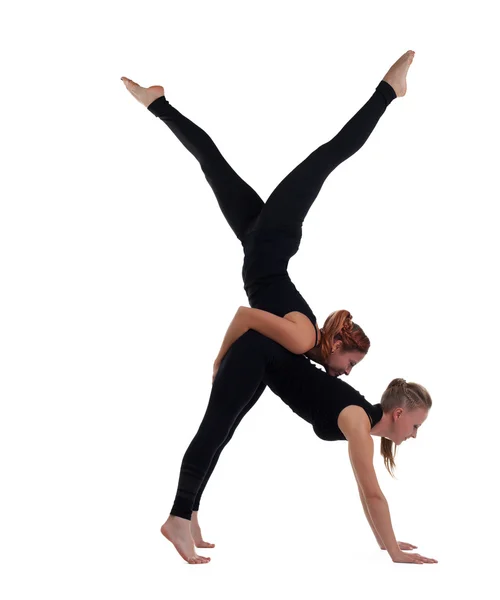 Two woman gymnast in black show acrobatic exercise — Stock Photo, Image