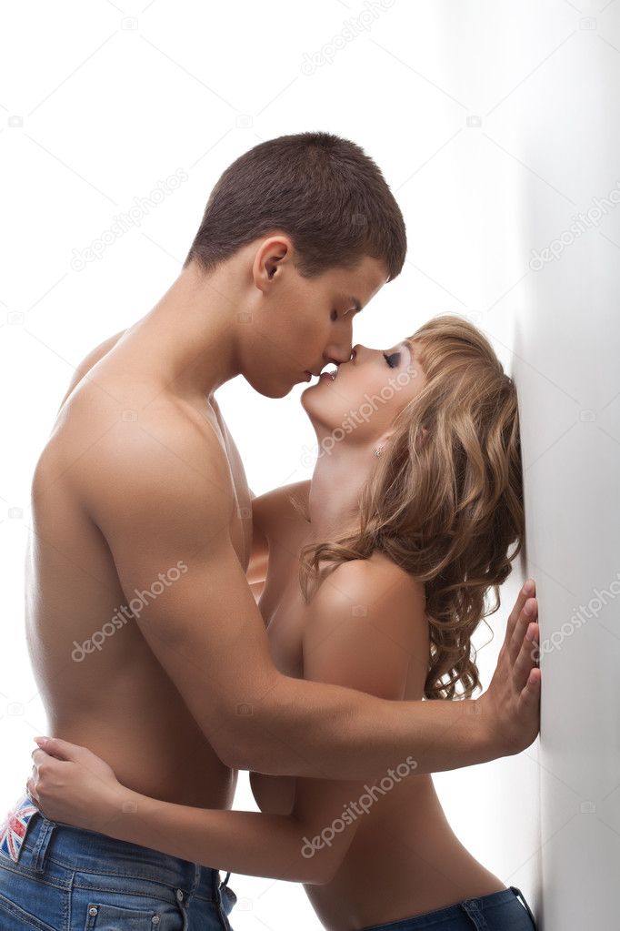 Athletic beauty man and sexy girl kissing topless