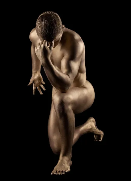 Naked strong man posing in gold skin — Stock Photo, Image