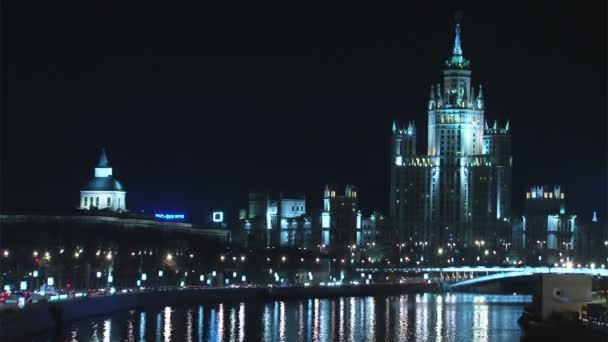 Tráfego noturno perto do edifício histórico à beira do rio com espelho — Vídeo de Stock