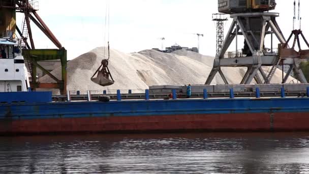 Grúa descarga grava de barcaza en el río — Vídeo de stock