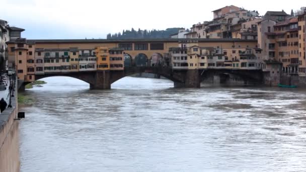Bridge and buildings over channel in winter Florence