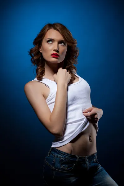 Sexy jonge vrouw in witte spijkerbroek tank top — Stockfoto