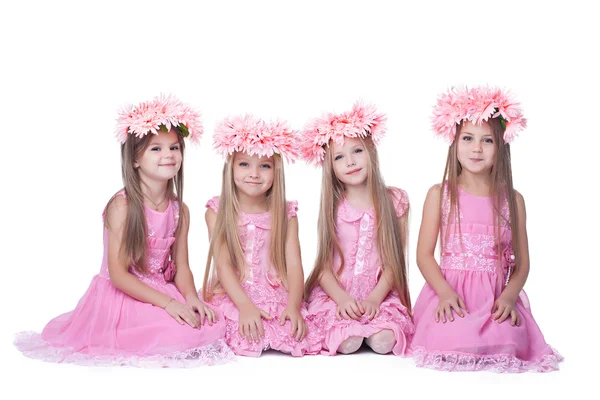 Quatre petites filles aux cheveux longs en robes roses — Photo