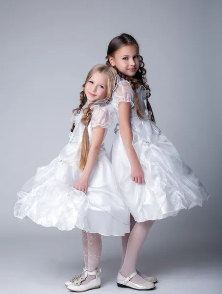 Iki sevimli küçük kız beyaz elbiseler — Stok fotoğraf
