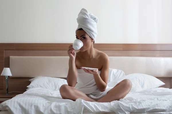 年轻女子在床上喝咖啡 — 图库照片