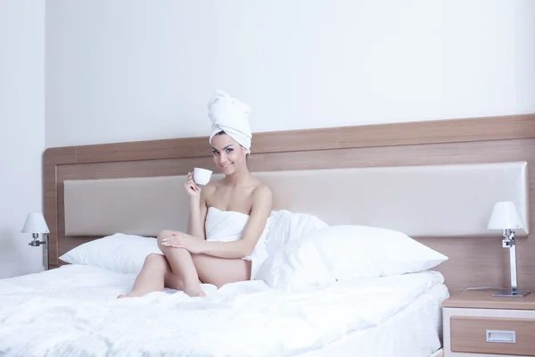 漂亮的年轻女人在床上喝咖啡 — 图库照片
