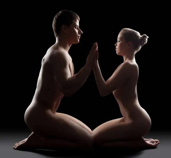 Jeune couple assis dans l'obscurité et prendre les mains — Photo