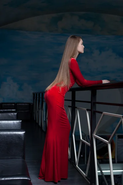 Mooie vrouw poseren in rode lange jurk — Stockfoto