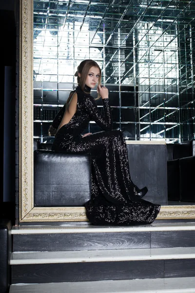 Schöne junge Frau im langen schwarzen Kleid — Stockfoto