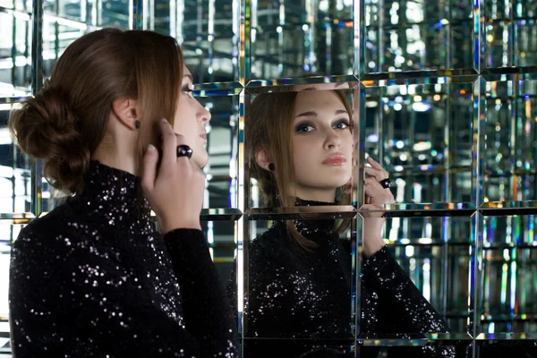 Beautiful woman in long black dress near mirror — ストック写真