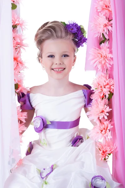 Schönes kleines Mädchen in der Nähe von rosa Blumen — Stockfoto