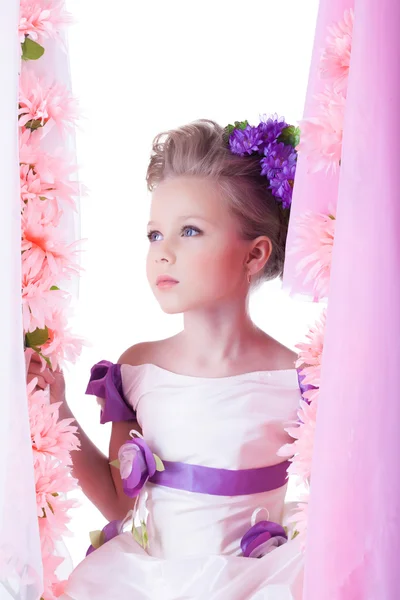 Niño bonito en columpio en flores rosadas — Foto de Stock