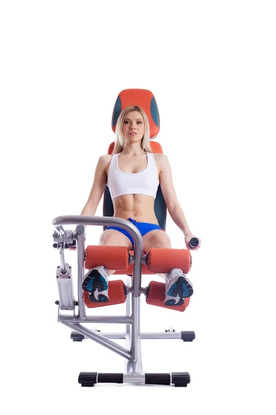 Blonde woman sitting on orange hydraulic exerciser — Stock Photo, Image