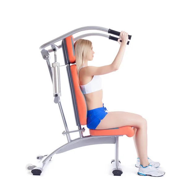 Young woman sitting on orange hydraulic exerciser — Stock Photo, Image