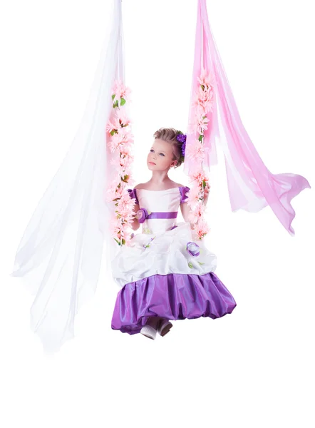 Hezká dívka, houpající se na květinové swing — Stock fotografie