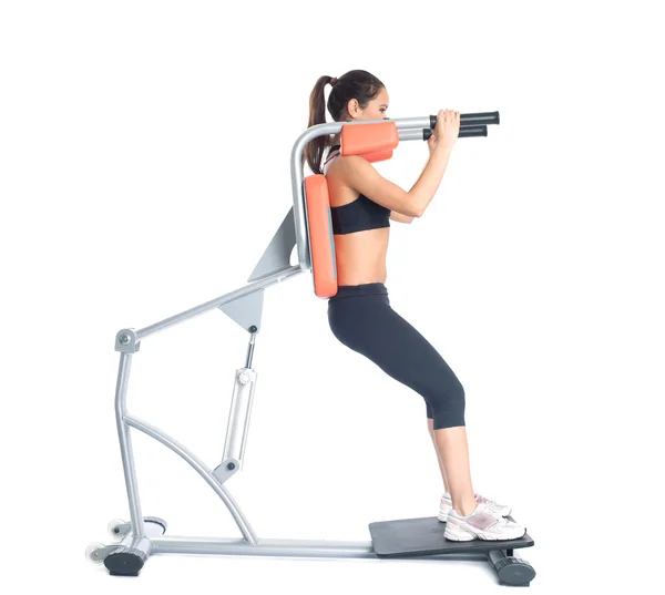 Bela mulher magra treina no exercitador — Fotografia de Stock