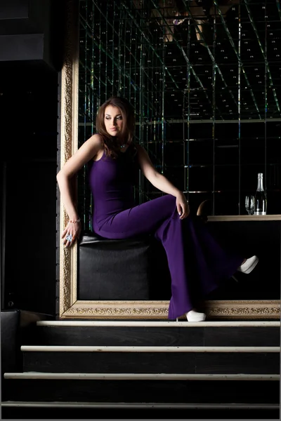 Sexy žena, sedící v dlouhé fialové šaty — Stock fotografie