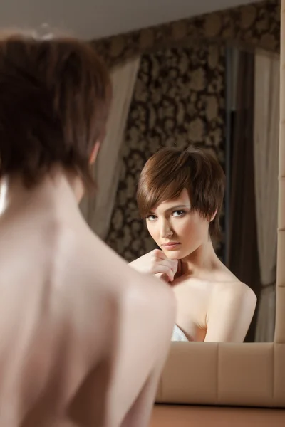 Reflection of attractive young brunette in mirror Stock Photo