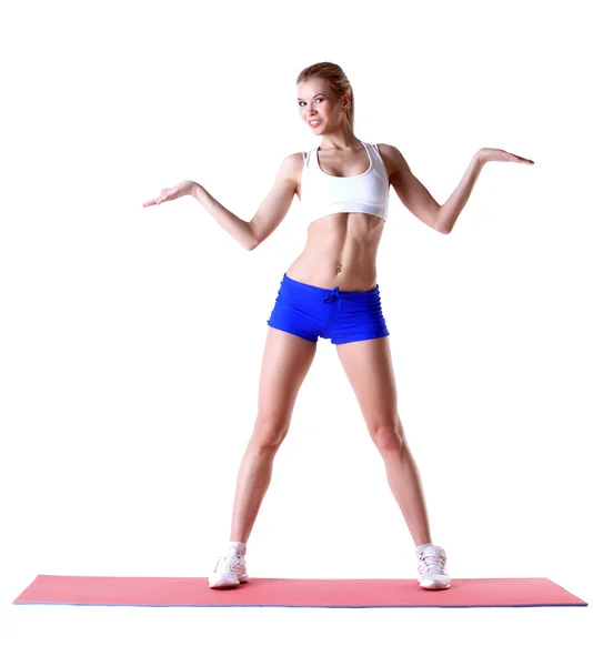 Vrolijke slanke vrouw die zich voordeed op mat in studio — Stockfoto