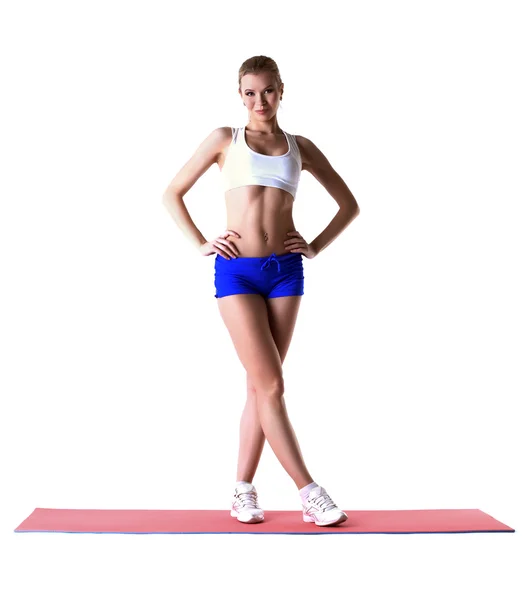 Beautiful slim woman posing on gymnastic mat — Stock Photo, Image