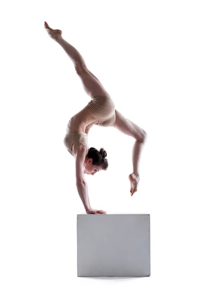 Junge flexible Frau posiert auf Würfel — Stockfoto