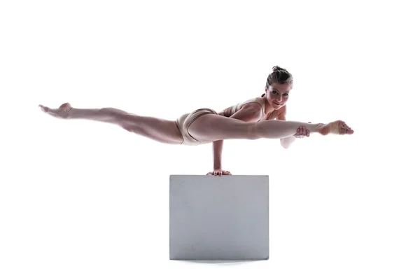 Attractive gymnast doing exercises on cube — Stock Photo, Image