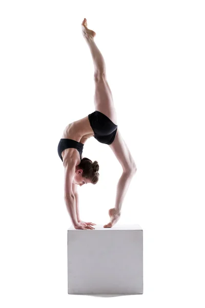 Ganska gymnast poserar på kub i studio — Stockfoto