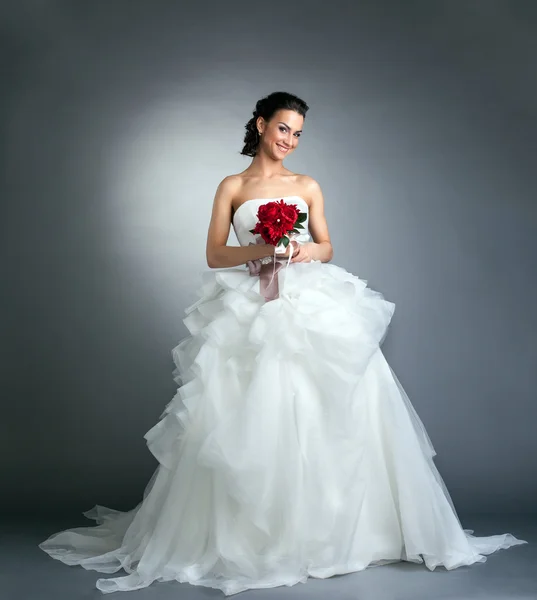 Charmante Braut mit Blumenstrauß posiert im Studio — Stockfoto