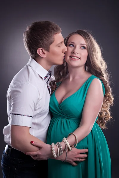Изображение мужчины целующегося с веселой беременной женщиной — стоковое фото