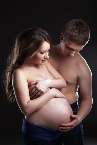 Young man caresses pregnant woman's belly — Stock Photo, Image