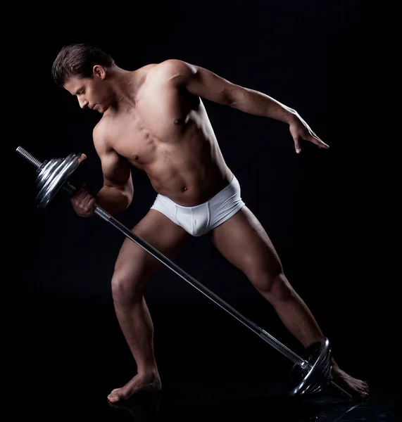 Guapo atleta levantando pesas en estudio — Foto de Stock