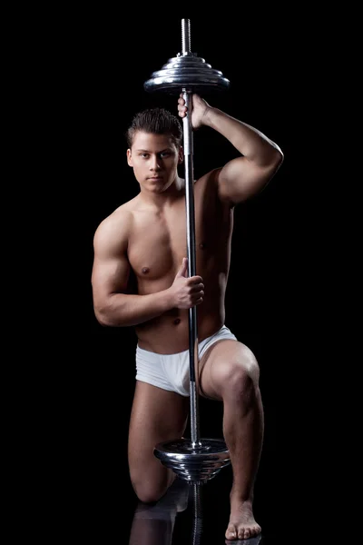 Attraente uomo muscoloso in posa con bilanciere — Foto Stock