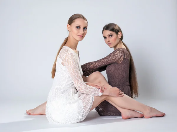 Chicas bonitas con el pelo largo posando en vestidos — Foto de Stock