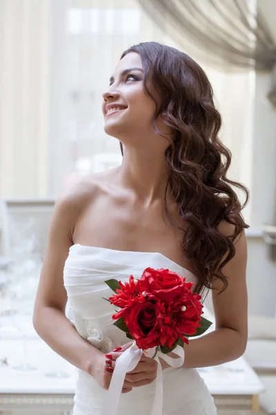 Retrato de noiva feliz posando com buquê vermelho — Fotografia de Stock