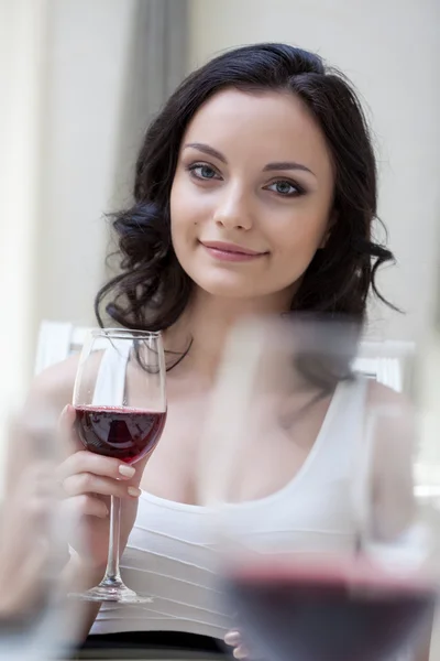 Hübsche Brünette posiert mit einem Glas Rotwein — Stockfoto