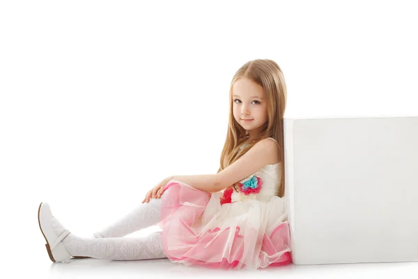 Adorable little girl posing leaning on cube — Stock Photo, Image