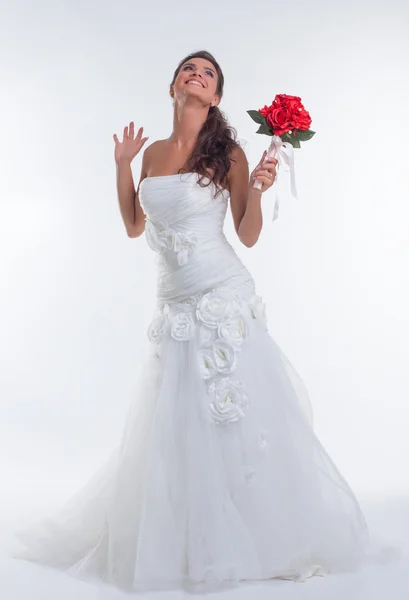 Mariée joyeuse posant avec bouquet de fleurs rouges — Photo