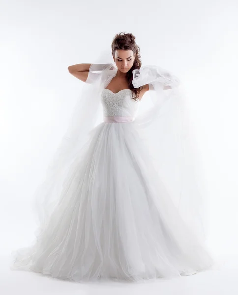 Hübsche Braut posiert in stylischem Kleid mit Schleier — Stockfoto