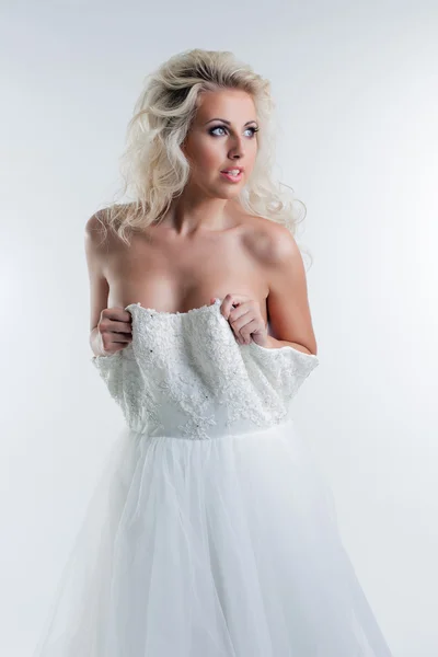 Sensual young blonde taking off wedding dress — Stock Photo, Image