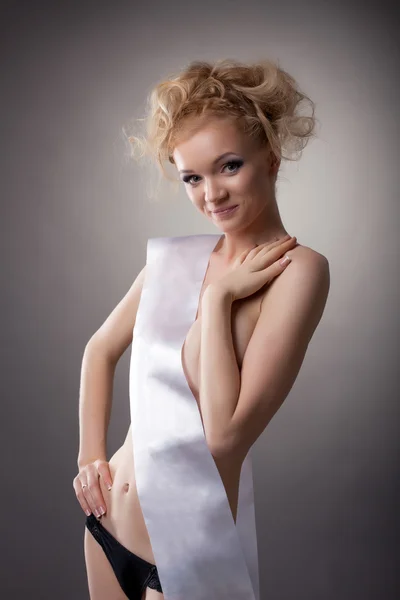 Smiling naked model with ribbon posing in studio — Stock Photo, Image