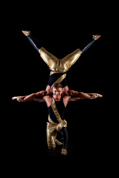Smiling muscular acrobats isolated on black — Stock Photo, Image