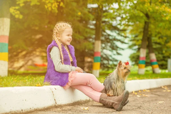 Sorridente bambina che cammina con Yorkshire Terrier — Foto Stock