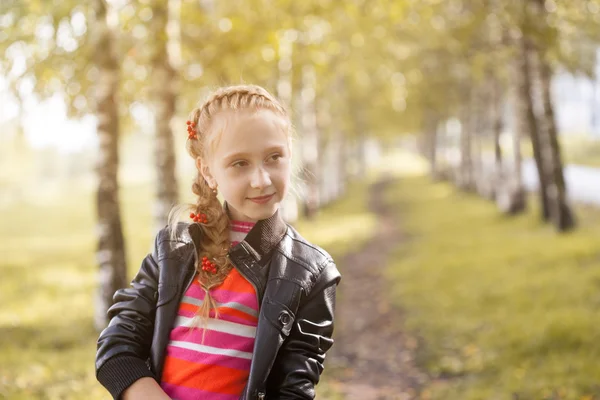 Charming little girl posing in autumn garden — Stock Photo, Image