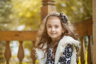 trendy kıvırcık küçük esmer kameraya gülümseyen