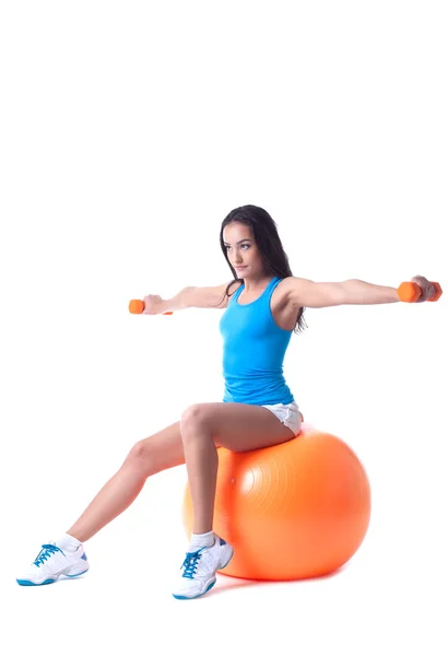 Confident girl exercising with dumbbells in studio — Stock Photo, Image