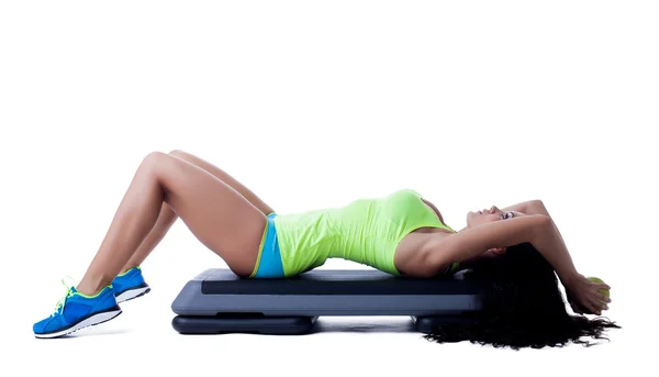 Slim athletic brunette doing aerobics on stepper — Stock Photo, Image