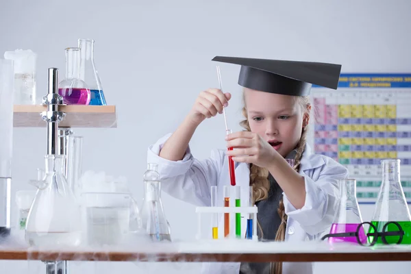 Surprised girl looking at test tubes with reagents — Stock Photo, Image